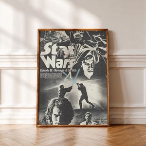 Könnte beinhalten: Ein schwarz-weißes Star Wars Episode III Die Rache der Sith Filmplakat in einem Holzrahmen. Das Plakat zeigt eine Collage aus Charakteren, darunter Darth Vader und Anakin Skywalker, sowie zwei Figuren im Duell mit blauen Lichtschwertern.