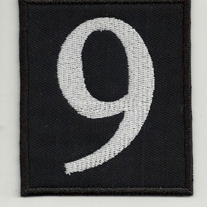 May include: White embroidered number nine on a black patch.