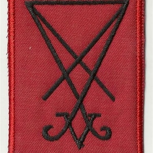 May include: A square, red patch with a black, stylized symbol. The symbol is a combination of intersecting lines and curves, resembling an inverted triangle and a cross. The patch has a red border.