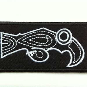 May include: White embroidered design of a stylized bird on a black fabric patch.