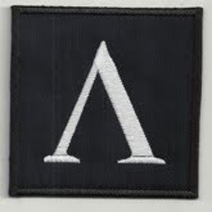 Puede incluir: Parche de tela negro con una letra A bordada en blanco.