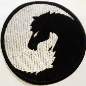 May include: Black and white embroidered patch of a horse's head in a yin yang design.