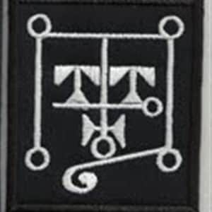 Peut inclure: Un écusson brodé noir avec un symbole blanc. Le symbole est un carré avec un cercle dans chaque coin. À l'intérieur du carré se trouve une ligne verticale avec une ligne horizontale au milieu. Il y a trois triangles sur la ligne horizontale. Une ligne courbe s'étend du bas de la ligne verticale.