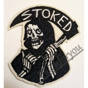 Op de afbeelding: Witte geborduurde patch met een zwart-witte afbeelding van de Grim Reaper die een zeis vasthoudt. Het woord "STOKED" is in wit geborduurd boven de Grim Reaper.