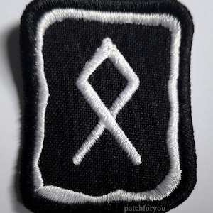 Puede incluir: Parche bordado negro con un contorno blanco y un símbolo blanco que se asemeja a una letra 'X' estilizada en su interior. El parche tiene el texto 'patchforyou' en blanco en la parte inferior.