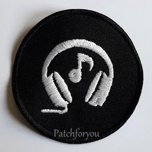 Op de afbeelding: Zwarte ronde patch met witte, geborduurde koptelefoon en een noot. De patch heeft de tekst "Patchforyou" onderaan.