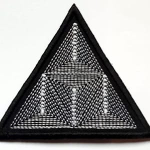 Peut inclure: Patch triangulaire noir avec un motif géométrique blanc complexe brodé dessus.