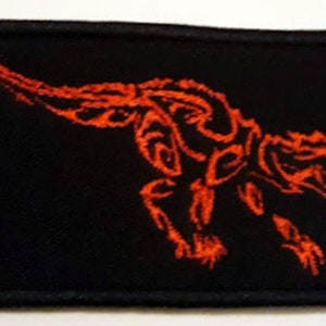Puede incluir: Parche bordado rojo con una imagen estilizada de un dragón sobre un fondo negro.