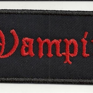 Può includere: Toppa rettangolare nera con il testo "Vampire" ricamato in rosso.