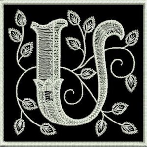 May include: A white embroidered letter "U" with a decorative floral design on a black background.