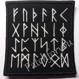 Peut inclure: Patch en tissu noir avec des runes brodées en blanc. Les runes sont disposées en quatre rangées de six runes chacune. Le patch mesure environ 10 cm sur 10 cm.