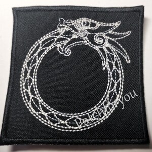 Può includere: Toppa ricamata bianca su sfondo nero con un drago stilizzato arrotolato in un cerchio. La toppa è per cucire o stirare su vestiti o borse.