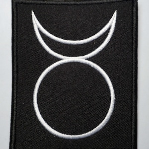 May include: A black fabric patch with a white embroidered symbol of a circle with a crescent moon above it.