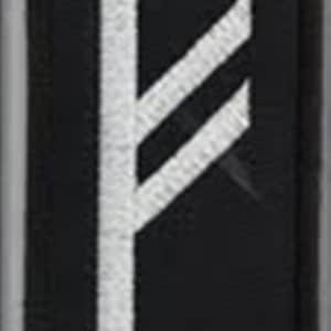 Könnte beinhalten: Schwarzer Patch mit einem weißen gestickten Runensymbol. Die Rune ist eine vertikale Linie mit zwei diagonalen Linien, die sich von oben erstrecken.