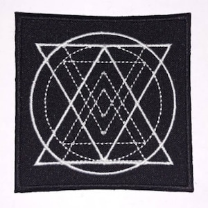 May include: Black fabric patch with a white geometric design. The design features a circle with a series of overlapping triangles and lines.