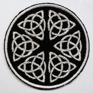 May include: A black and white embroidered patch with a Celtic knot design. The knot is a circle with six points, each with a triangular shape. The patch is about 3 inches in diameter.