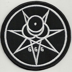 Op de afbeelding: Een geborduurde patch in zwart en wit met een zespuntige ster, een cirkel met een stip in het midden en het getal 666.