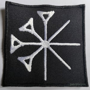 Könnte beinhalten: Weißer gestickter Aufnäher auf schwarzem Hintergrund. Das Design ist ein sechszackiger Stern mit einem Kreis in der Mitte.