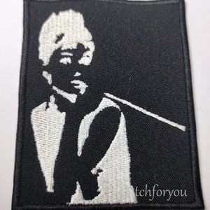 Op de afbeelding: Zwart en wit geborduurde patch met een afbeelding van een persoon die rookt. Het ontwerp toont een witte silhouet op een zwarte achtergrond. De tekst "tchforyou" is zichtbaar in de rechter benedenhoek van de patch.
