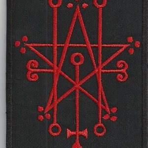 Peut inclure: Patch brodé rouge avec un pentagramme et d'autres symboles sur un fond noir.