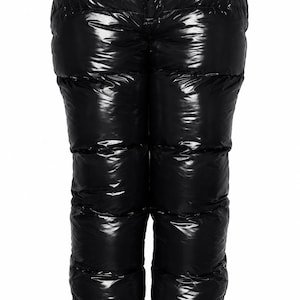 Può includere: Pantaloni neri a vita alta con una finitura lucida effetto vernice. Questi pantaloni trapuntati presentano impunture orizzontali lungo le gambe, una chiusura frontale con bottone e una vita strutturata dotata di passanti per la cintura.