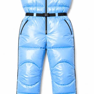 Peut inclure: Une combinaison sans manches bleu clair en duvet avec une finition brillante. Elle présente un col montant, une fermeture éclair centrale noire et une ceinture noire avec une boucle en plastique. Elle inclut deux poches latérales zippées.