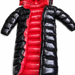 Peut inclure: Un long manteau doudoune noir brillant avec une doublure intérieure rouge vif. Ce vêtement matelassé à capuche présente une ouverture frontale sur toute la longueur, des manches longues et une finition très brillante contrastant avec l'intérieur rouge.