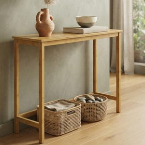 May include: A rectangular bamboo console table with four straight legs and a flat top surface. On the table sits a terracotta vase, a book, and a two-toned bowl. Underneath, two woven baskets are placed, one containing folded fabric.
