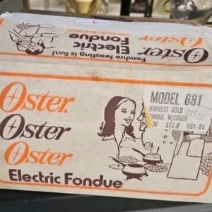 May include: A vintage Oster Electric Fondue box featuring orange and brown text and graphics. The box displays the Oster logo, the words Electric Fondue, and a line drawing of people eating. A white label on the box reads Model 681 Harvest Gold.