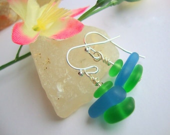 May include: A pair of silver dangle earrings with blue and green glass beads. The beads are stacked on top of each other and are a mix of round and oval shapes.