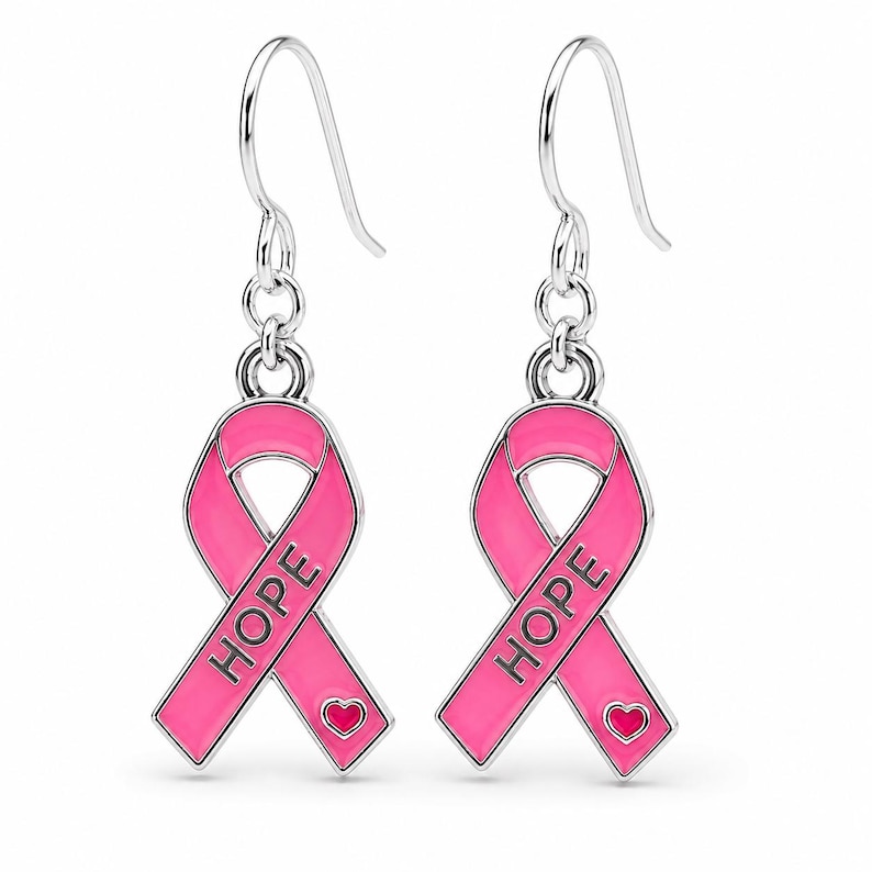May include: A pair of silver-toned drop earrings featuring a pink enamel awareness ribbon design. Each ribbon is embossed with the word HOPE in black capital letters and includes a small pink heart detail at the bottom, suspended from silver hooks.