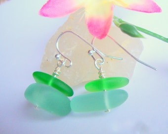 May include: A pair of silver earrings with two green glass beads on each earring. The beads are oval shaped and translucent.