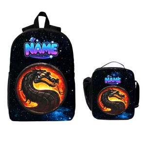May include: A black backpack and matching lunch bag set featuring a space-themed background with stars and planets. Both items display the word NAME in blue and purple gradient letters above a circular graphic of a black dragon over fire.