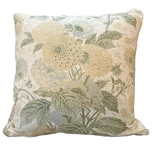 May include: Square decorative pillow with a floral pattern in shades of cream, green, and pale blue. The design features large, stylized flowers and foliage, creating a vintage aesthetic. The pillow is likely made of a soft fabric.