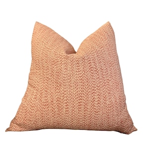 May include: A red and white patterned throw pillow with a chevron design.