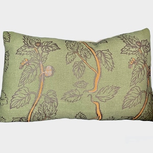May include: A green rectangular cushion with a floral pattern in brown and orange. The cushion has a subtle linen texture.