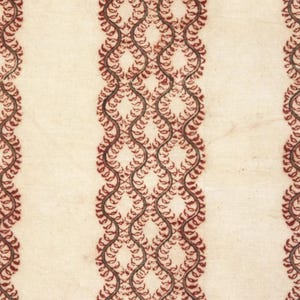 Puede incluir: Tela de color crema con tres columnas verticales de un patrón de hojas rojo oscuro, ornamentado y repetitivo. El diseño es simétrico, con el patrón de hojas formando una cadena ondulada e interconectada sobre el fondo neutro. La tela tiene una estética ligeramente envejecida o vintage.