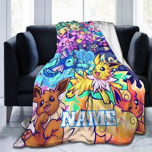 May include: A soft fleece blanket featuring a colorful collage of various Eevee evolution characters in vibrant shades of yellow, blue, pink, and brown. The word NAME is printed in large, bold, light blue letters across the center of the design.