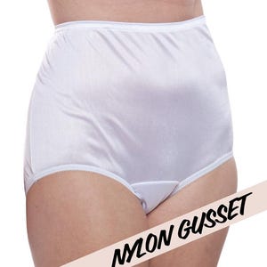 Puede incluir: Braga blanca de talle alto confeccionada en tejido liso y opaco, con un delicado borde festoneado a lo largo de las aberturas de las piernas. La prenda incluye un refuerzo de nailon en la entrepierna, presentada con el texto NYLON GUSSET.