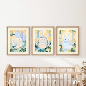 Peut inclure: Trois impressions d'art mural encadr&eacute;es repr&eacute;sentant un hibou, un h&eacute;risson et un lapin. Chaque animal est illustr&eacute; dans une for&ecirc;t aux tons jaunes et bleus, portant une &eacute;charpe bleu clair, entour&eacute; de feuillage vert et d'arbres.