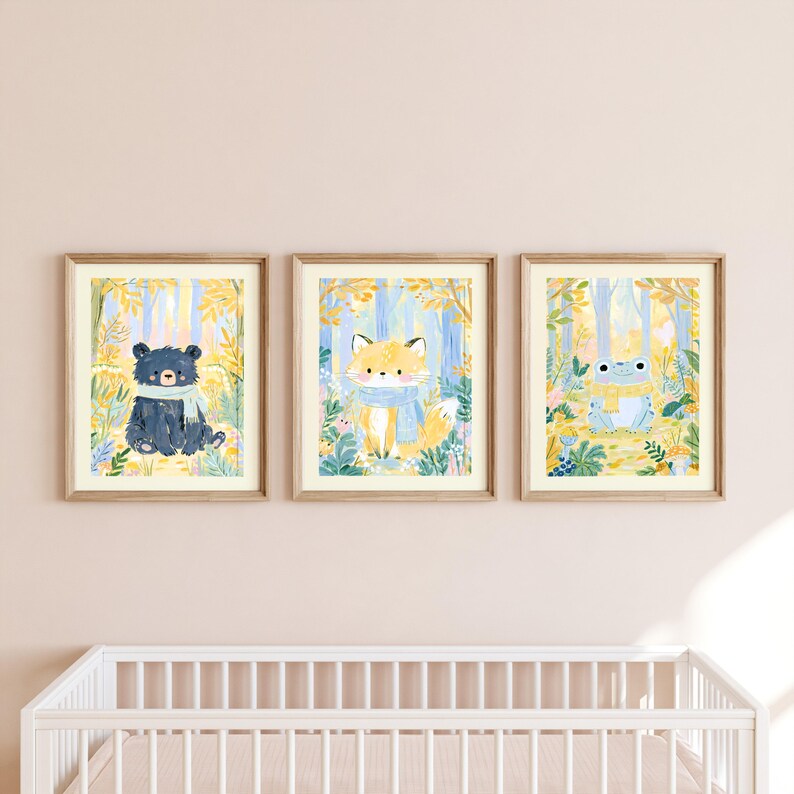 Peut inclure: Trois cadres muraux pr&eacute;sentant des illustrations &agrave; l'aquarelle d'un ours noir avec une &eacute;charpe bleue, d'un renard avec une &eacute;charpe bleue et d'une grenouille avec une &eacute;charpe jaune, sur un fond de feuillage forestier jaune et bleu.