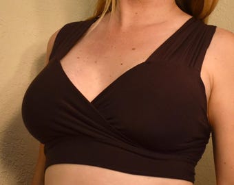 Puede incluir: Un top marrón oscuro sin mangas, de estilo cruzado, con un escote en V profundo.