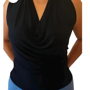 May include: A black sleeveless top with a cowl neck and a halter style. The top is made of a soft, stretchy fabric.
