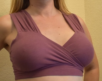 May include: A mauve-colored, sleeveless, wrap-style top with a deep V-neckline.