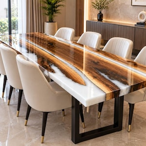 Puede incluir: Una mesa de comedor rectangular con una pieza central de madera de borde natural con acabado brillante, flanqueada por secciones de resina blanca. La mesa se apoya en un marco de metal negro y está rodeada por seis sillas blancas tapizadas con patas negras.