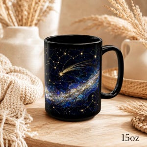 May include: A black ceramic mug with a 15 oz capacity, featuring a vibrant celestial design of a golden shooting star, swirling blue and purple nebula clouds, and a network of thin gold lines connecting small stars across a dark night sky.
