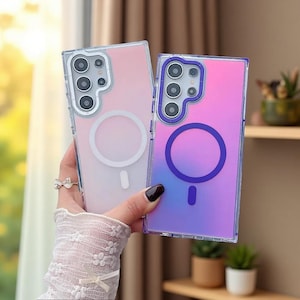 May include: Two rectangular smartphone cases with a gradient finish. The left case is a soft pink to white gradient with a white circular magnetic ring. The right case is a vibrant pink to blue gradient with a dark purple circular magnetic ring.