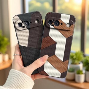May include: Two smartphone cases featuring a geometric wood-grain pattern in shades of dark brown, light brown, and cream. Each case has a horizontal camera bar cutout at the top, showcasing a textured, multi-toned wood veneer design.