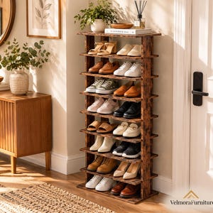 May include: A tall, dark brown wooden shoe rack with nine horizontal shelves, filled with various styles of footwear including sneakers, loafers, and sandals. The unit features a rustic, distressed finish and is positioned against a white wall.