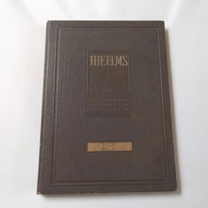 May include: A dark brown leather-bound book with gold lettering. The title is "The Elms" and the year is "1926".